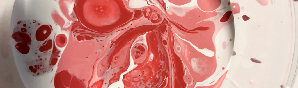 close-up photo different colors of paint swirled in a cup